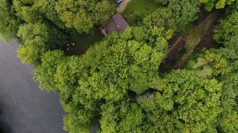 A Diagonal Low Altitude Flight Across a Cottage to the Trees Stock Footage 79989197