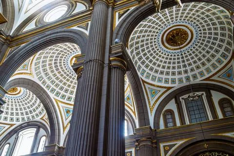 Diagonal low angle view of towering fluted column and ornate coffered ceilings w Stock Photos