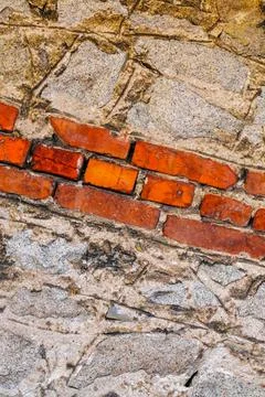 Diagonal pattern of red bricks embedded in rough stone masonry with aged te.. Stock Photos