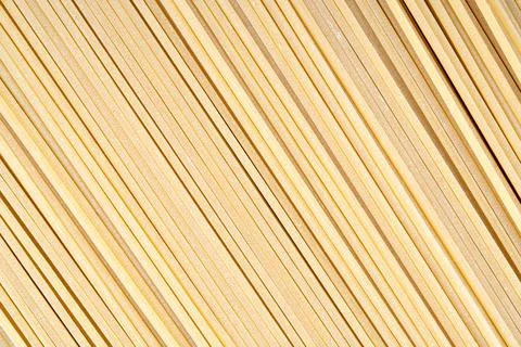 Diagonal pattern of uncooked spaghetti pasta background Stock Photos
