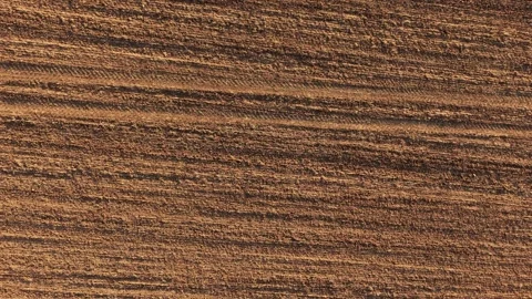 Diagonal perspective of plowed land with layered soil lines and tractor marks Stock Footage 339343362