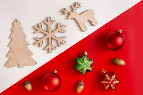 On a diagonal red and white background, flat natural wooden Christmas toys Stock Photos