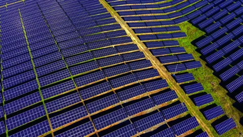 Diagonal rows of solar panels cross rural field Stock Footage 340407539