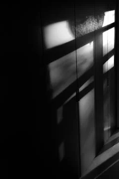 Diagonal shadows add reflections on the dark wall Foto stock