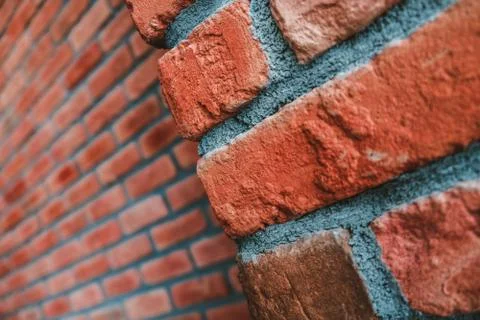 Diagonal side angle of a red brick wall corner. Close up view of cracked wall Stock Photos