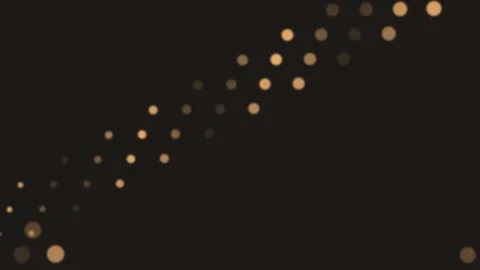 A diagonal string of soft golden bokeh lights against a dark background Video stock 335117901