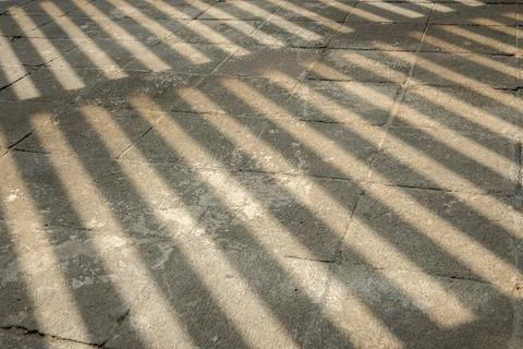 Diagonal striped shadows falling on stone pavement texture Fotos de archivo