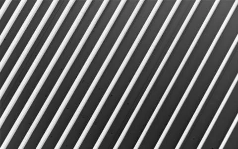 Diagonal stripes of light and shadow form geometric pattern on modern surface 스톡 사진
