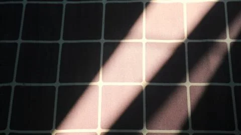 Diagonal sunlight and shadow on checkered fabric Stock Photos