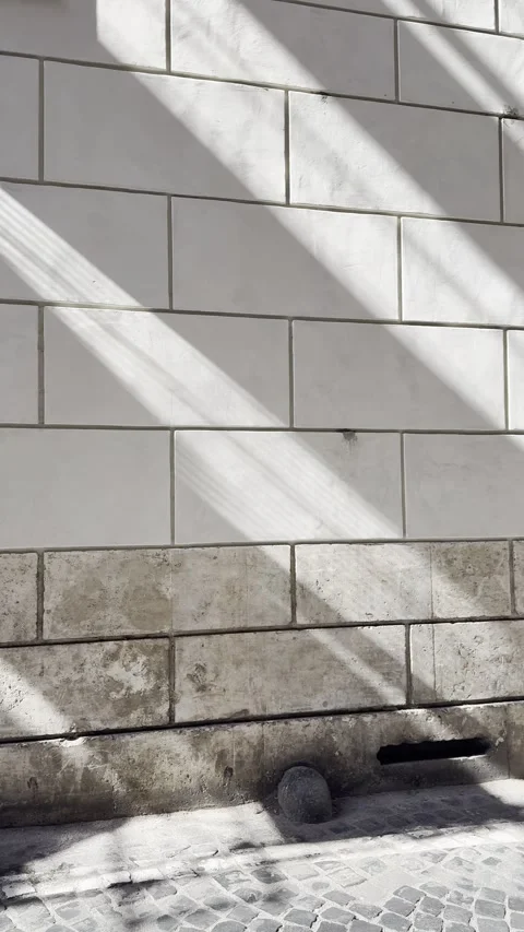 Diagonal Sunlight on Historic Stone Wall and Cobblestone Street Texture Stock Footage 340353638
