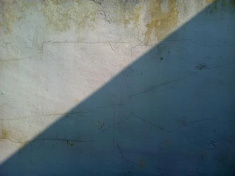 Diagonal sunlight shadow contrast on old cracked wall texture Stock Photos