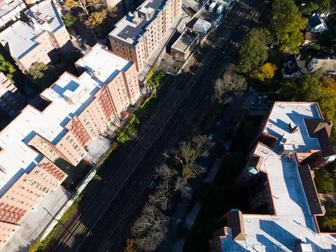 Diagonal top down drone view of railway tracks between apartment buildings Stock Photos