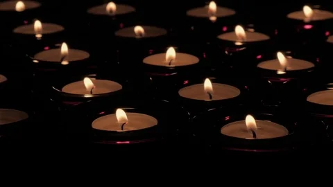 Diagonal tracking in shot of flickering tealight candle flames Video stock 73954773