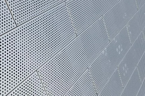 Diagonal view of metal dot pattern pannels on ceiling background Foto stock