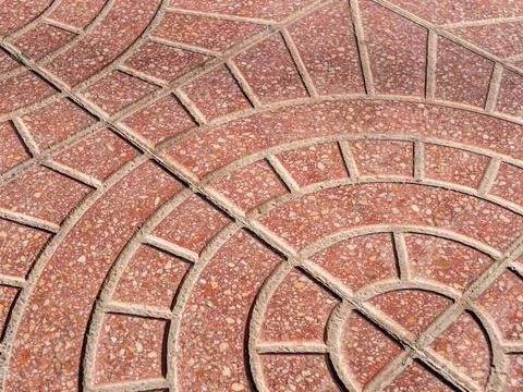 Diagonal view on a rounded pattern on a red stone pavement Stock Photos