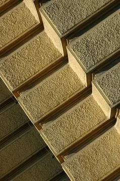 Diagonal view of yellow rusticated stucco building corner Stock Photos