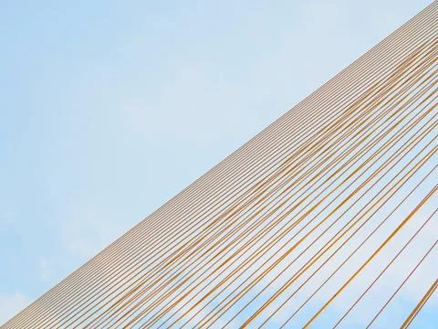 Diagonal yellow stack cable line, on blue sky background Foto stock