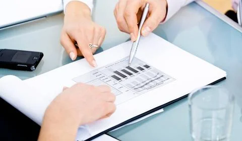 Diagram on table Open folder with visible diagram lying on desk and hands ... Stock Photos