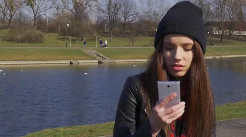 Dialing and calling phone young woman in park daytime Stock Footage 48361814