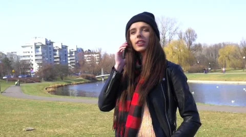 Dialing and calling phone young woman in park daytime Stock Footage 48361817