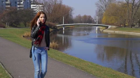 Dialing and calling phone young woman in park daytime Stock Footage 48361826