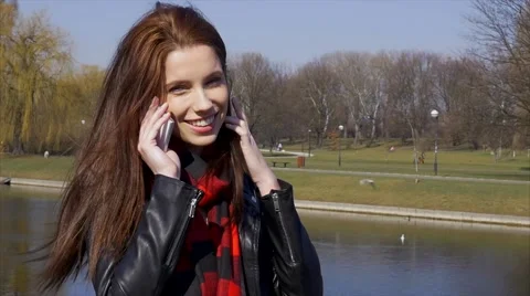 Dialing and calling phone young woman in park daytime Stock Footage 48361828