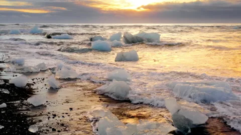 Diamond Beach in Iceland. Chunks of ice washing by Ocean waves at sunrise Stock Footage 167512586