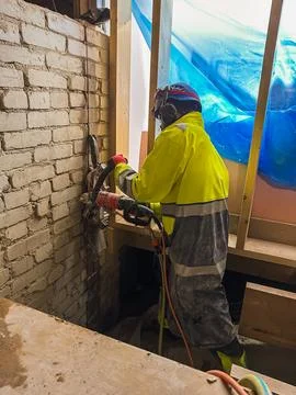 Diamond cutting of brick structure using ring saw during building renovation. Stock Photos