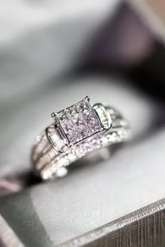 A diamond engagement ring in a box with glint/reflection. Shimmering princess Foto stock