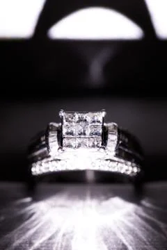 A diamond engagement ring in a box with glint/reflection. Shimmering princess Stock Photos
