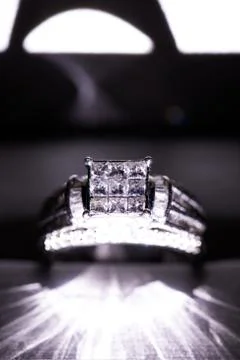 A diamond engagement ring in a box with glint/reflection. Shimmering princess Stock Photos