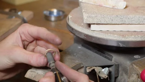 Diamond gold wedding ring in the making and getting polished on the inside Stock Footage 248977919