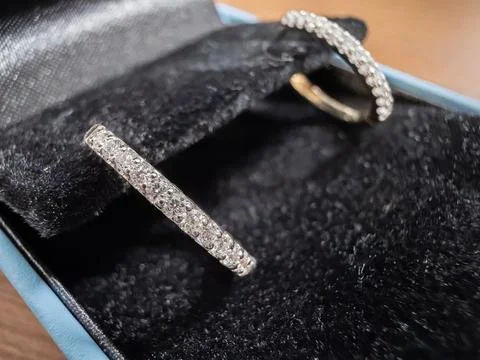 Diamond hoop earrings resting inside a plush black velvet jewelry gift box, Stock Photos
