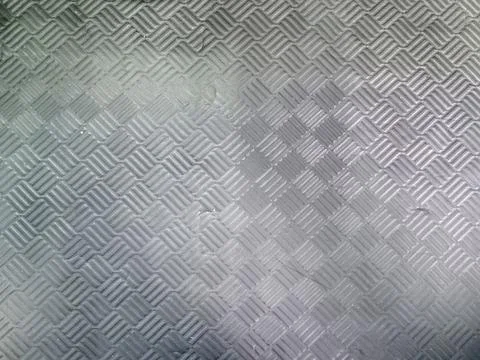 Diamond plate metal texture background forming a repeating geometric patter.. Stock Photos