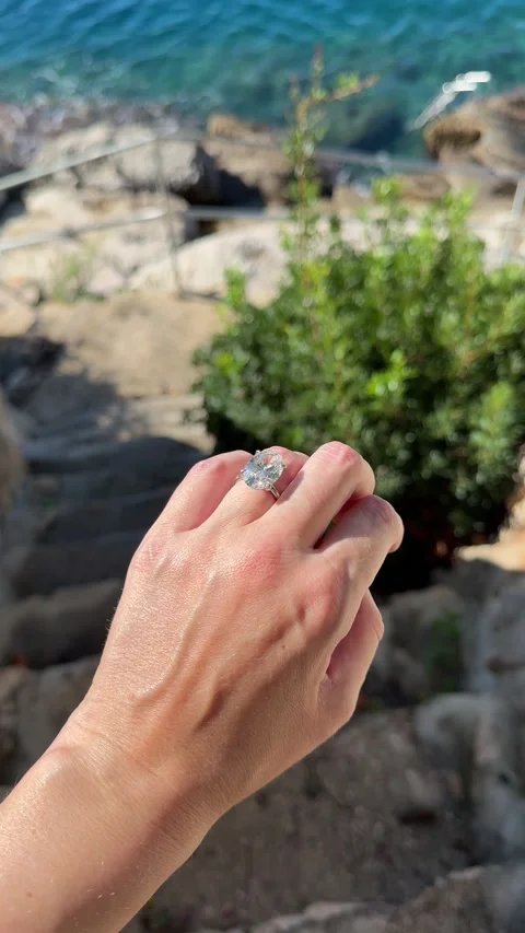 Diamond ring hand above cliffs and turquoise water in Croatia Stock Footage 319693764