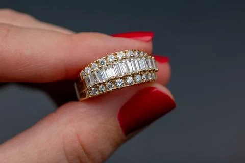 Diamond ring in the hand on a dark background. Close-up. Stock Photos
