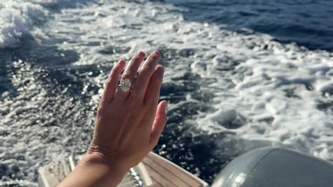 Diamond ring shining as hand reaches toward foamy Mediterranean waves Video stock 319406918