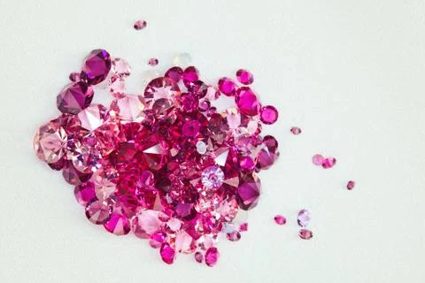 Diamond (ruby) stones heap over cream silk cloth background Stock Photos
