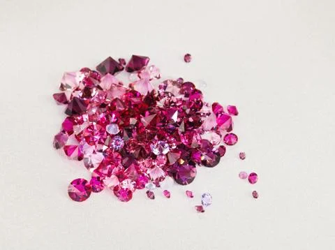 Diamond (ruby) stones heap over cream silk cloth background Foto stock