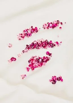 Diamond (ruby) stones heap over cream silk cloth background Stock Photos