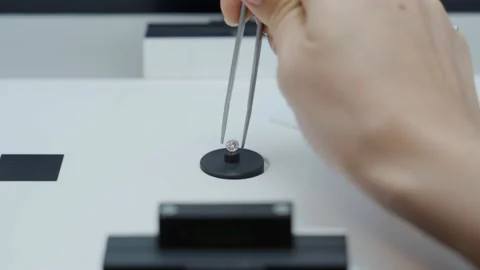 Diamond is set inside special macro photo booth, hand with tweezers takes it out Stock-Footage 154278660