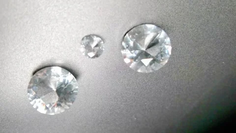 Diamonds on black surface with light passing on them 動画素材 343633877