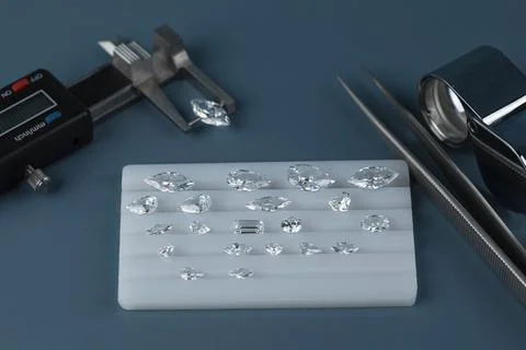 Diamonds of different sizes at the workplace of diamond dealer evaluating Stock Photos
