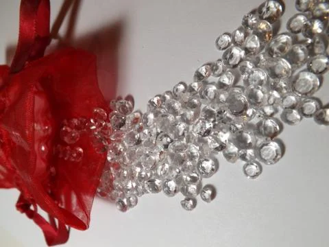 Diamonds  on a plane background with a red net bag Stock Photos