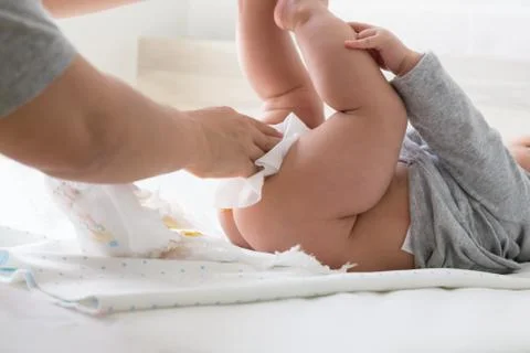 Diaper changing and cleaning bottom of baby 写真素材