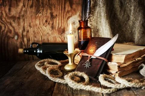 Diary and feather with a bottle of rum various vintage elements on old wor... Stock Photos