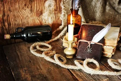 Diary and feather with a bottle of rum various vintage elements on old wor... Stock Photos