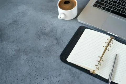 Diary with blank sheets, a Cup of black coffee, a gray laptop, a silver pen o Stock Photos