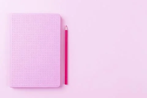 Diary or notepad with red pencil on pink background, flat lay copy space Foto stock