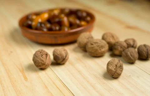 Dice and nuts on a background of pine wood. Stock Photos